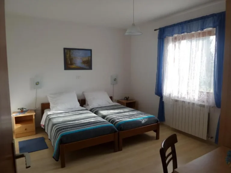 Appartement 2 : chambre avec lits et rideaux bleus