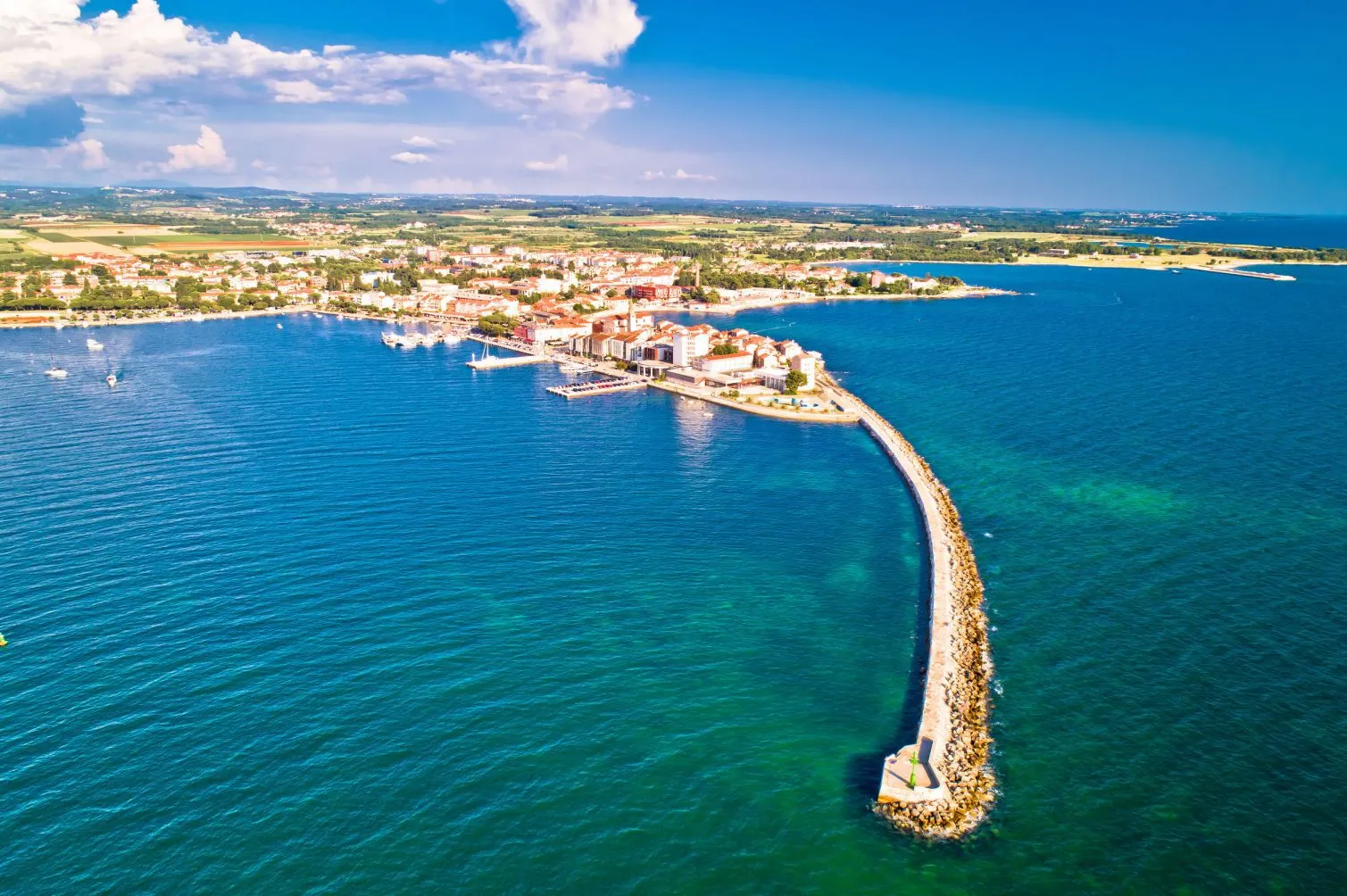 Umag aus der Luft: die Altstadt auf der Halbinsel, der Wellenbrecher und das türkisfarbene Meer